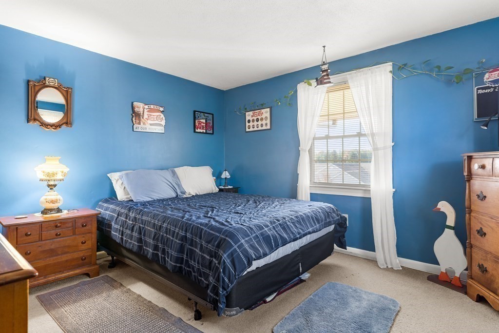 18 Woodman Way, Unit 17 Newburyport, MA 01950 - Photo 6 of 24 a bedroom with a bed and a window