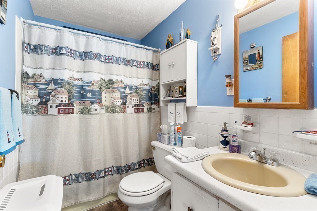 18 Woodman Way, Unit 17 Newburyport, MA 01950 - Photo 8 of 24 a bathroom with a sink a toilet and shower curtain
