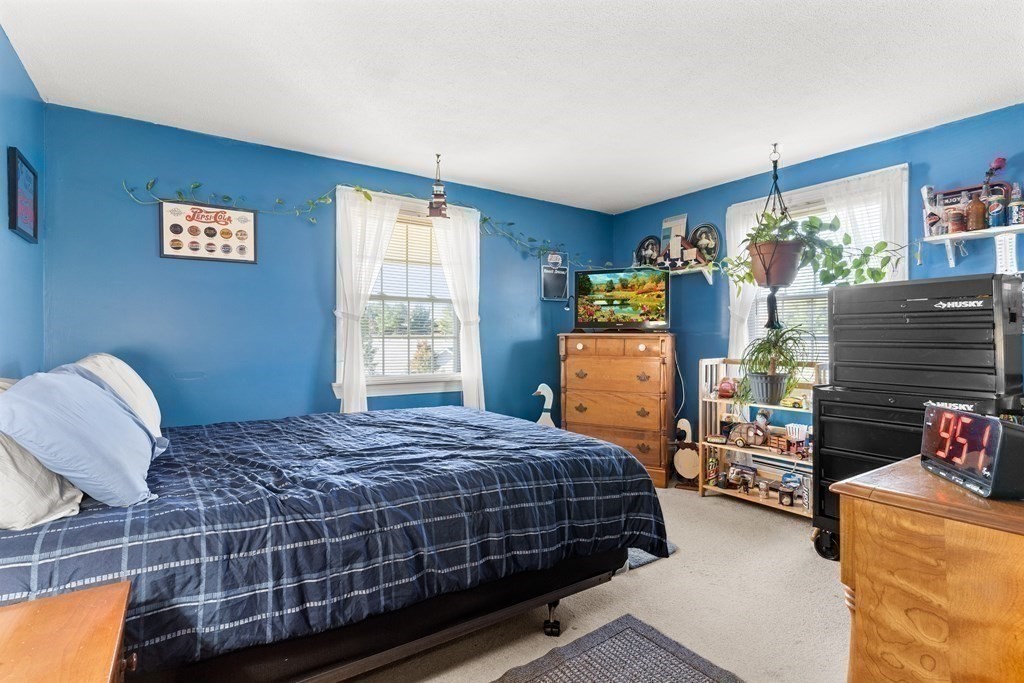 18 Woodman Way, Unit 17 Newburyport, MA 01950 - Photo 10 of 24 a bedroom with a bed and large windows