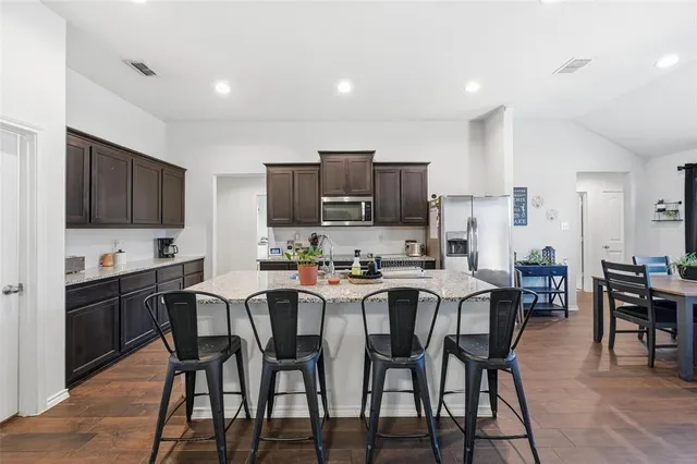 a kitchen with granite countertop a sink stainless steel appliances and cabinets