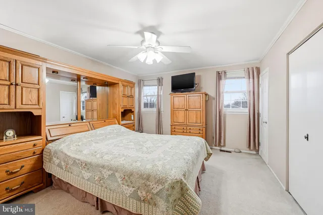 a bedroom with a bed and a flat tv screen on dresser