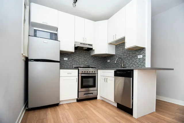 a kitchen with stainless steel appliances granite countertop a refrigerator and a stove