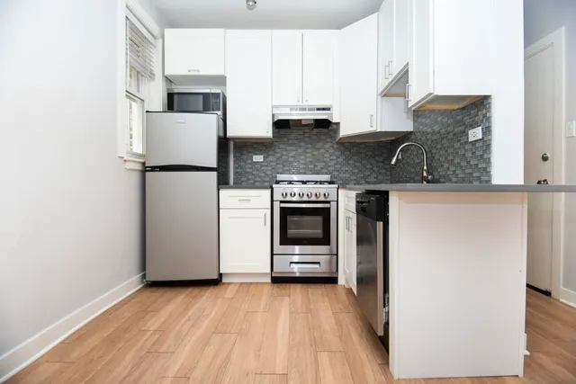 a kitchen with stainless steel appliances granite countertop a refrigerator sink and stove