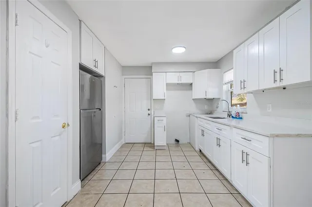 a kitchen with stainless steel appliances a refrigerator sink and cabinets