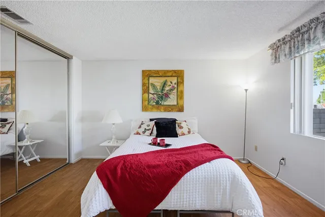 a bedroom with a bed and wooden floor
