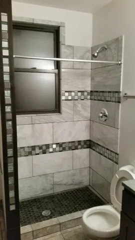 a bathroom with a toilet and a shower