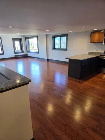 a living room with hard wood floors and a kitchen view