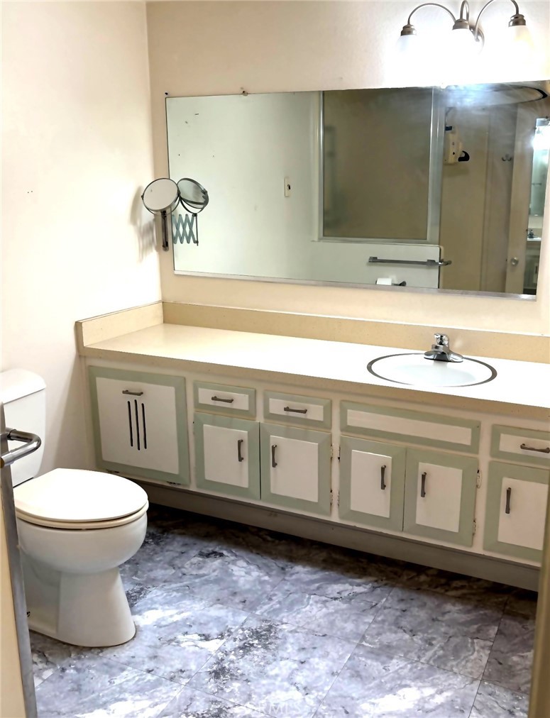 1075 Brookline Road, Unit M9220E Seal Beach, CA 90740 - Photo 15 of 16 a bathroom with a toilet sink and mirror