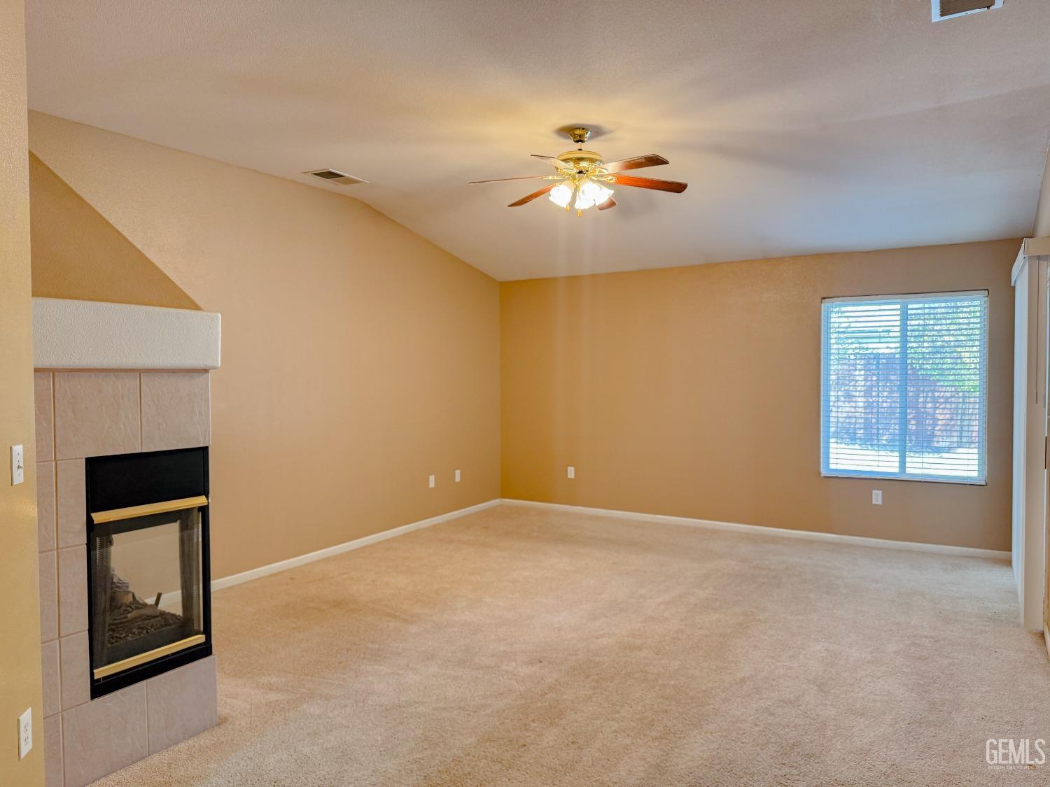 Undisclosed Address Bakersfield, CA 93312 - Photo 13 of 32 a view of an empty room with chandelier fan and fire place