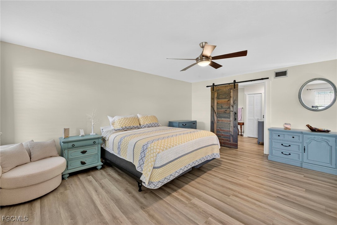 1823 Stevenson Road North Fort Myers, FL 33917 - Photo 18 of 32 a spacious bedroom with a bed and a chandelier