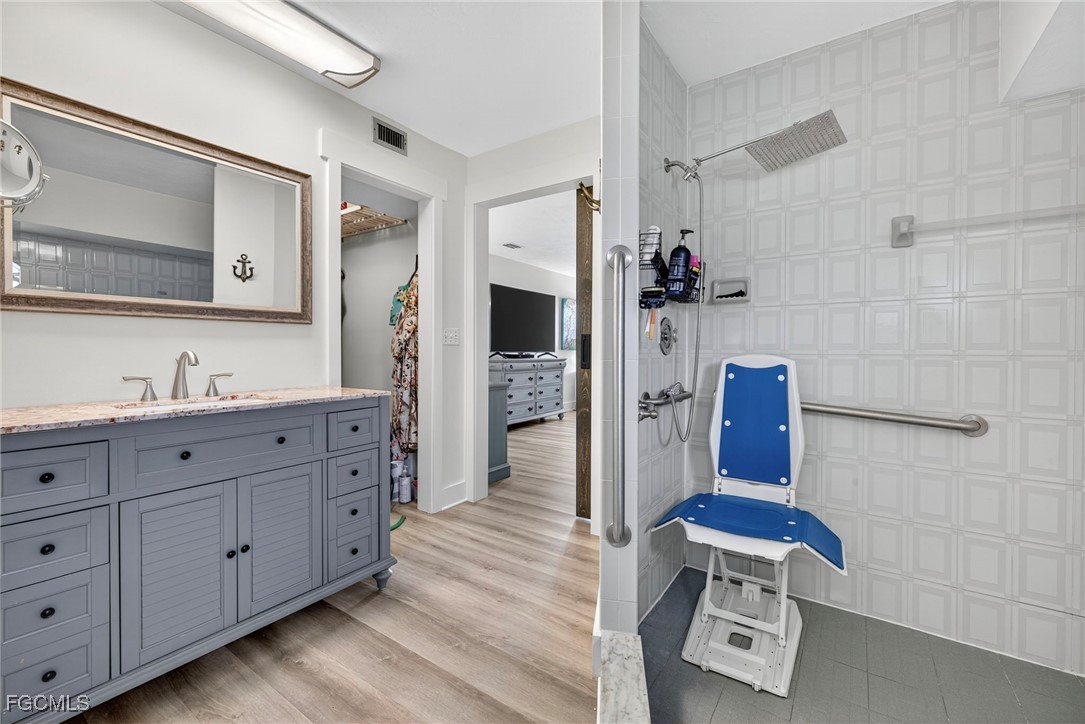1823 Stevenson Road North Fort Myers, FL 33917 - Photo 20 of 32 a spacious bathroom with a double vanity sink a large mirror and shower