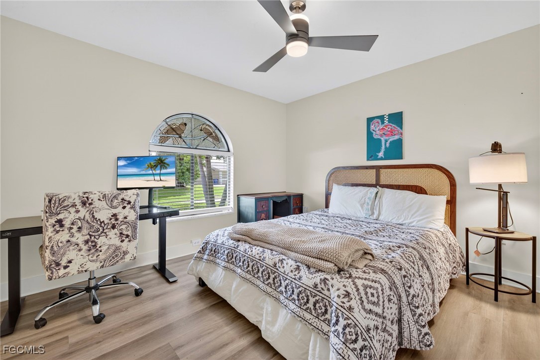 1823 Stevenson Road North Fort Myers, FL 33917 - Photo 23 of 32 a bedroom with a bed a desk and chair with the wooden floor