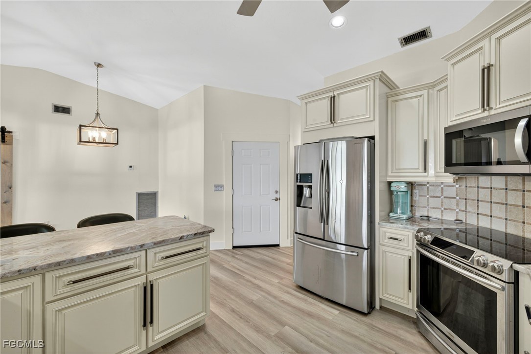 1823 Stevenson Road North Fort Myers, FL 33917 - Photo 7 of 32 a kitchen with stainless steel appliances a refrigerator sink and microwave