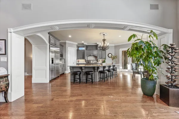 a kitchen with stainless steel appliances a dining table chairs stove refrigerator and cabinets