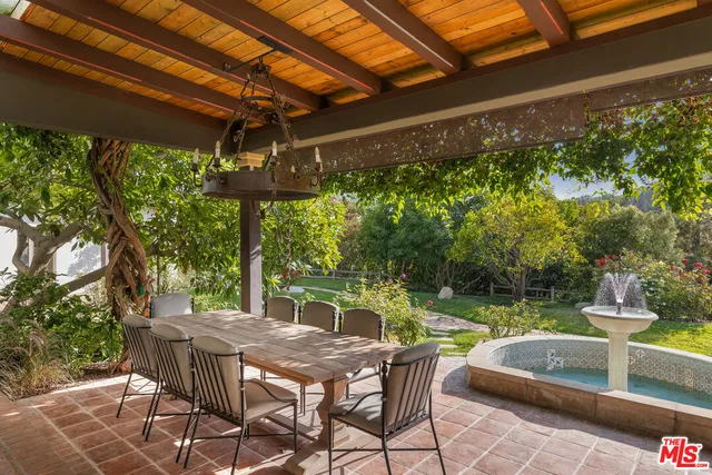 a view of backyard with a table and chairs under an umbrella