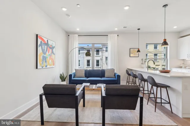 a living room with furniture and kitchen view
