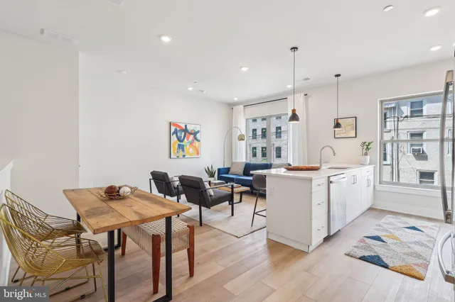 a large white kitchen with a table and chairs