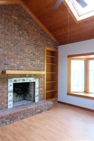 a view of an empty room with a fireplace and a window