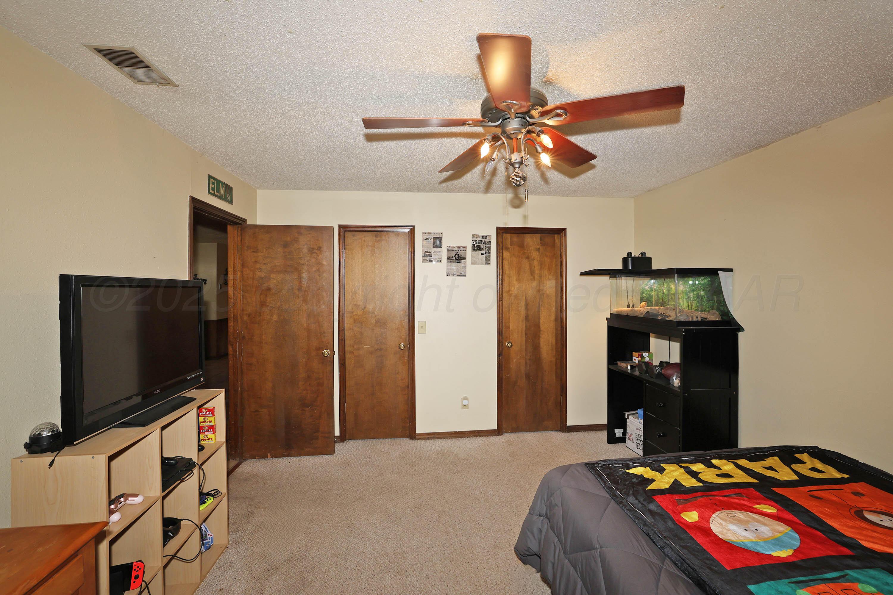 6225-6227 Belpree Road Amarillo, TX 79106 - Photo 13 of 31 a bedroom with a bed and a flat tv screen on the dresser