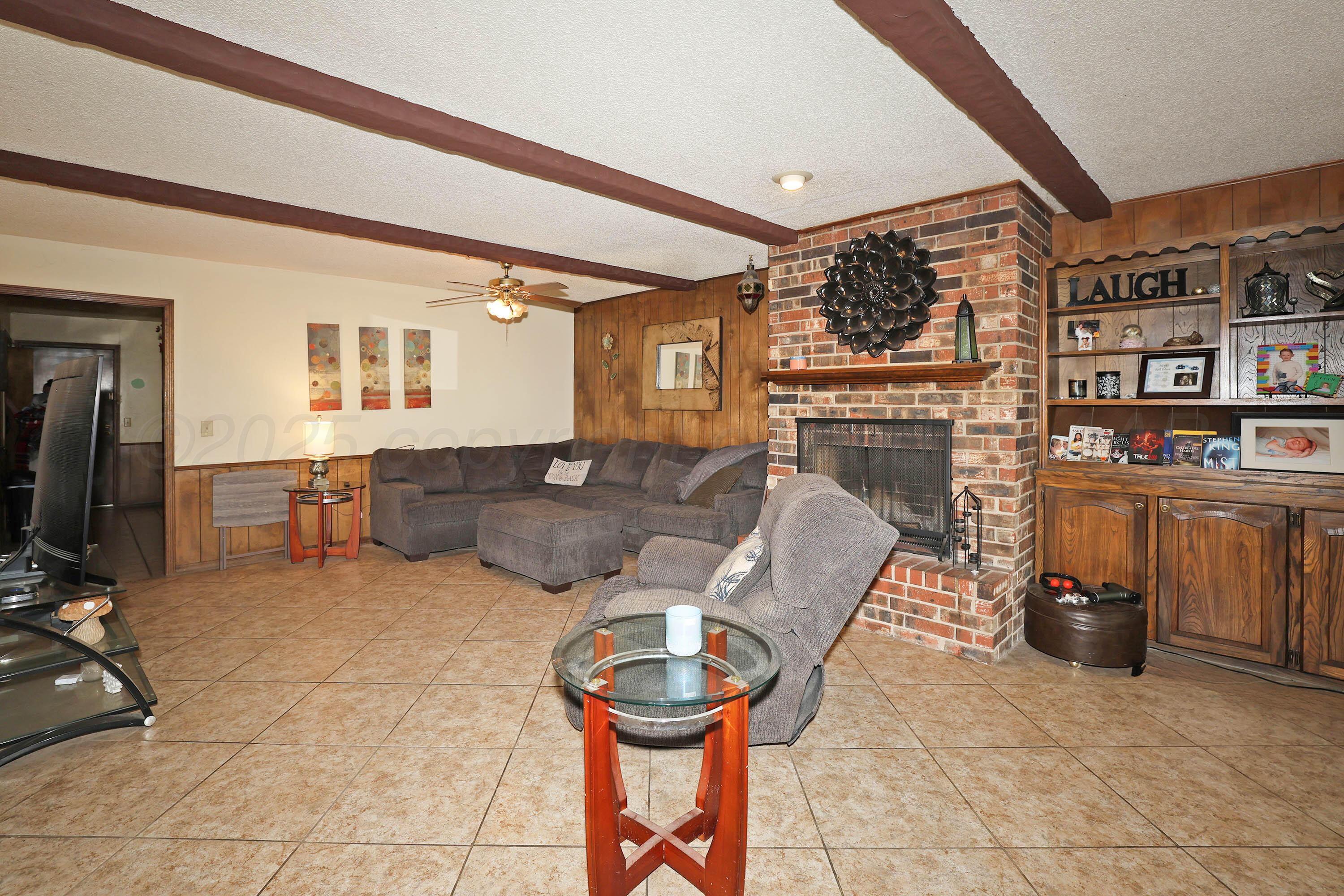 6225-6227 Belpree Road Amarillo, TX 79106 - Photo 3 of 31 a living room with furniture a fireplace and a flat screen tv