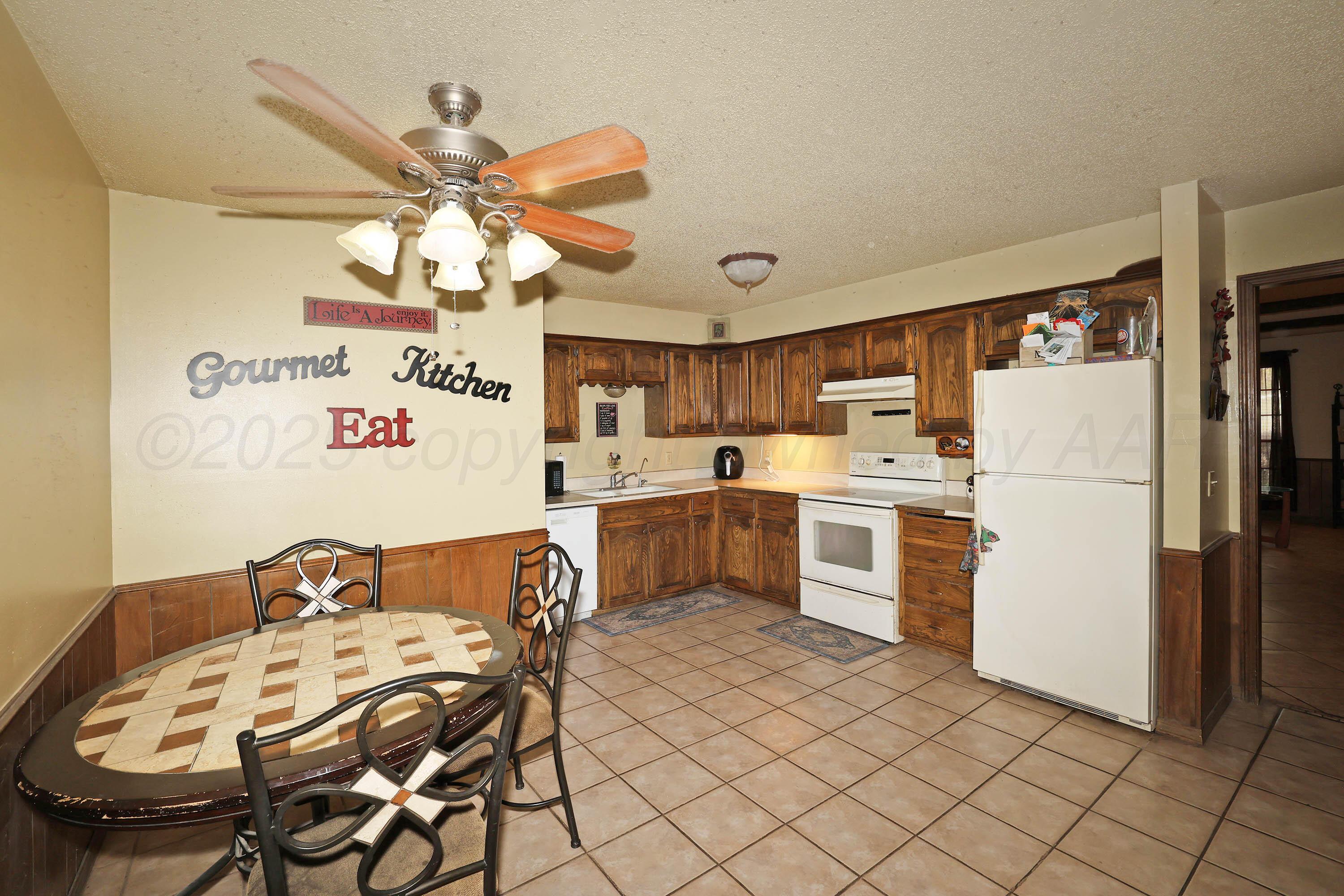 6225-6227 Belpree Road Amarillo, TX 79106 - Photo 5 of 31 a kitchen with a table chairs stove and refrigerator