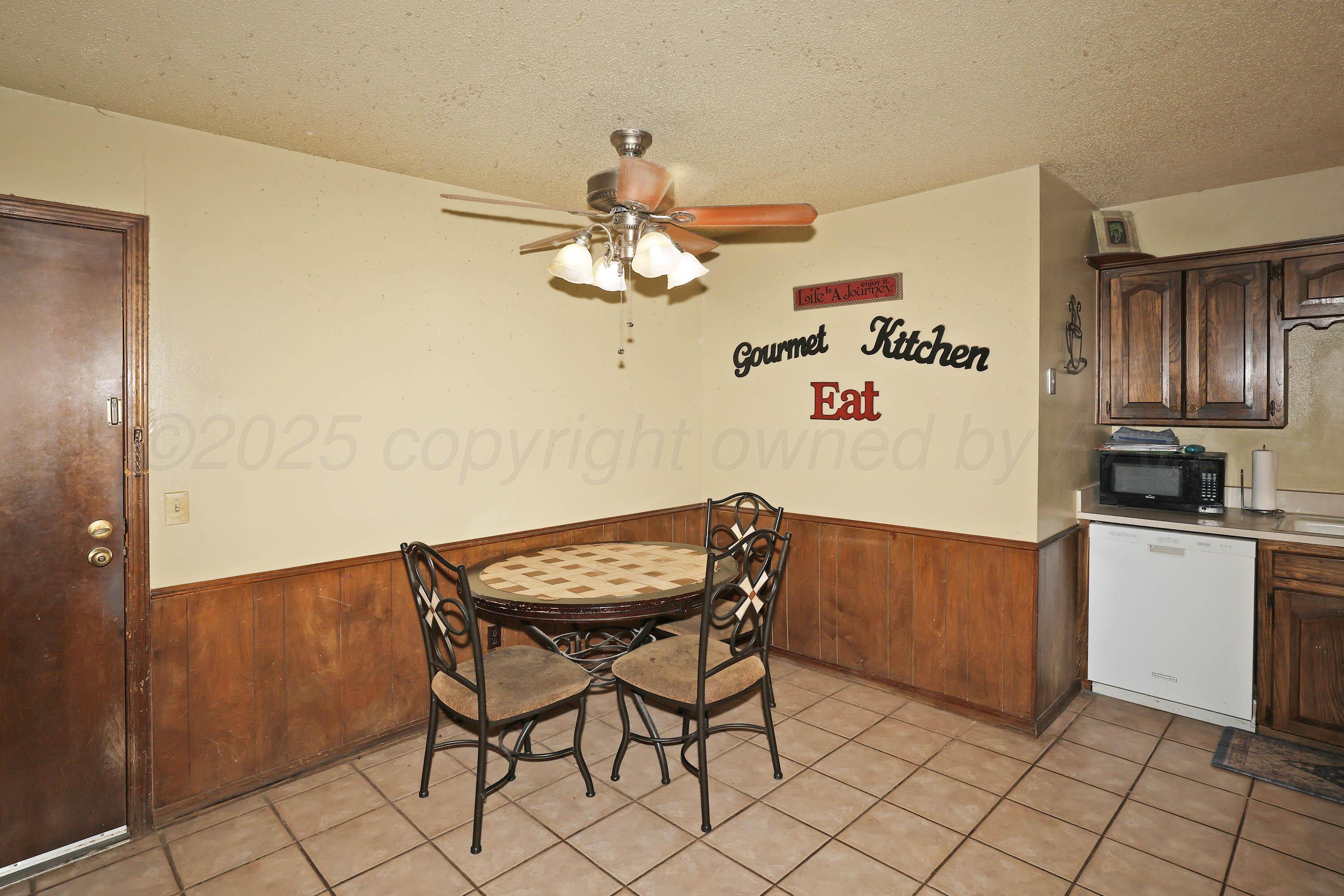6225-6227 Belpree Road Amarillo, TX 79106 - Photo 7 of 31 a kitchen with a dining table and cabinets