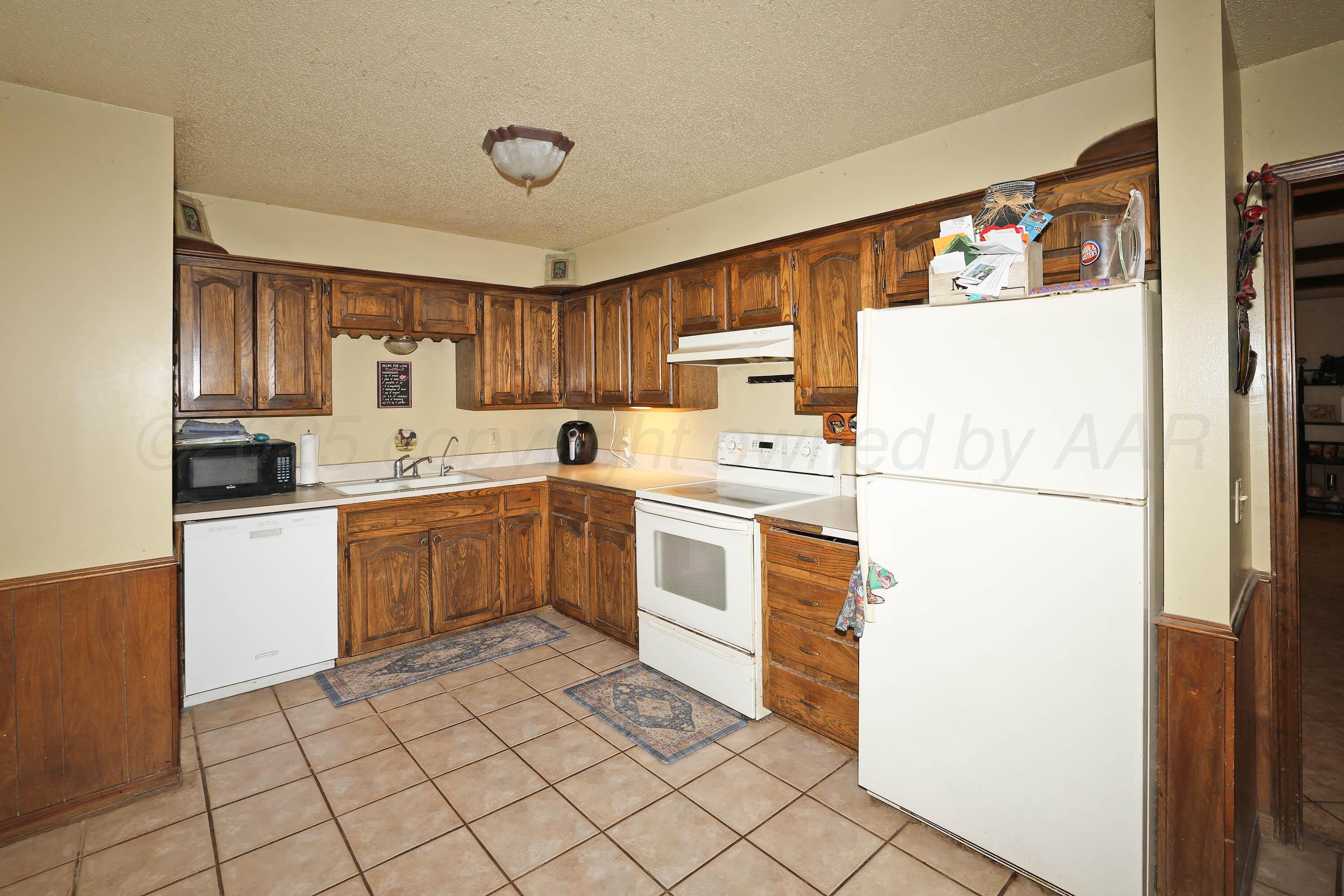6225-6227 Belpree Road Amarillo, TX 79106 - Photo 9 of 31 a kitchen with a refrigerator sink and cabinets