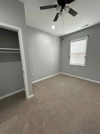 an empty room with a ceiling fan and a window