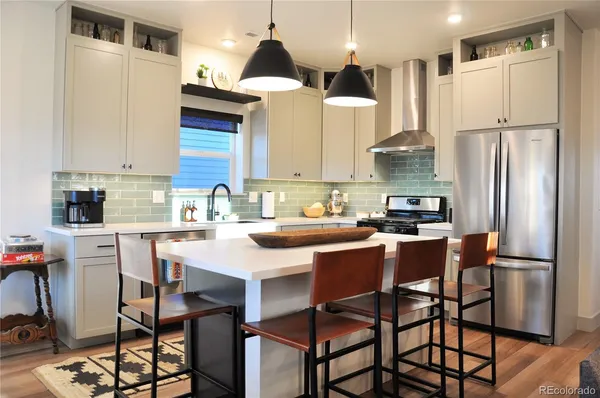 a kitchen with stainless steel appliances granite countertop a stove and a wooden floor