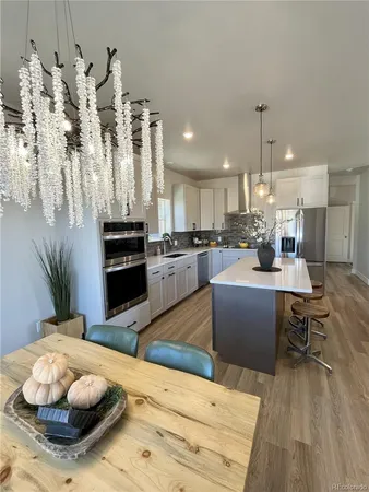 a kitchen with refrigerator and chairs