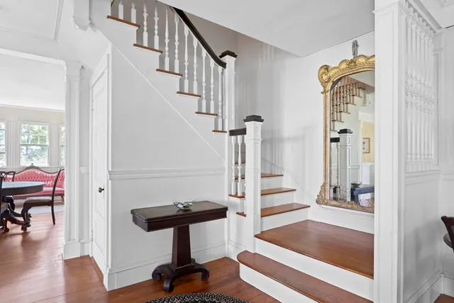 a view of a hallway with wooden floor and staircase