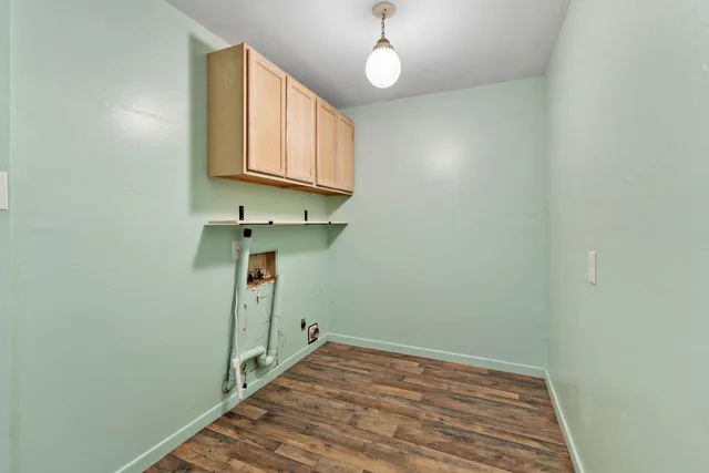 a view of a hallway with wooden floor and a chandelier