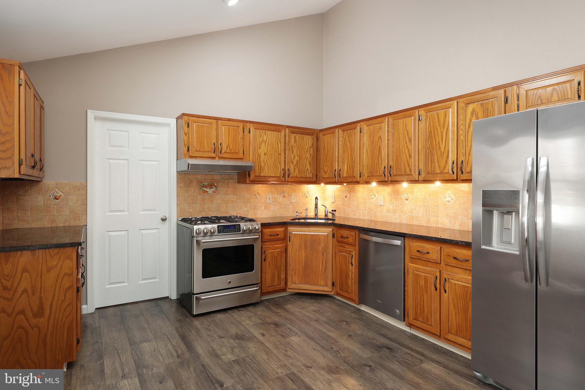 285 Manor Boulevard Hamilton, NJ 08620 - Photo 14 of 35 a kitchen with granite countertop a refrigerator stove and wooden floor