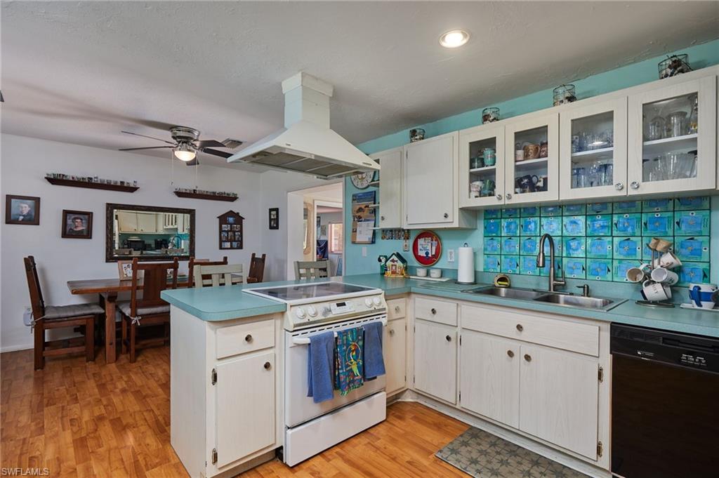 1660 South Hermitage Road Fort Myers, FL 33919 - Photo 9 of 21 a kitchen with a sink dishwasher and white cabinets with wooden floor