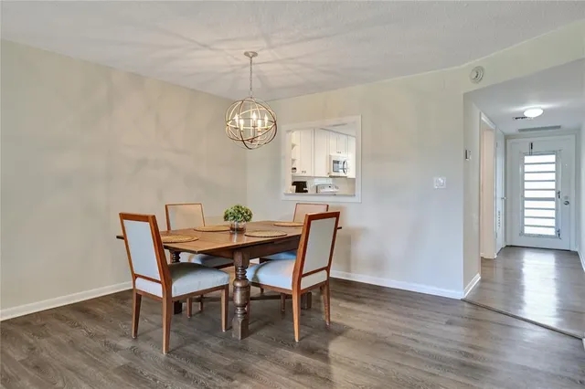 a view of a dining room with furniture a chandelier and wooden floor