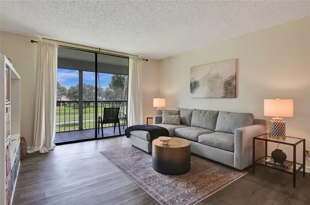 a living room with furniture lamp and a floor to ceiling window