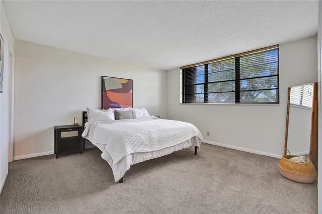 a bedroom with a bed and painting on the wall