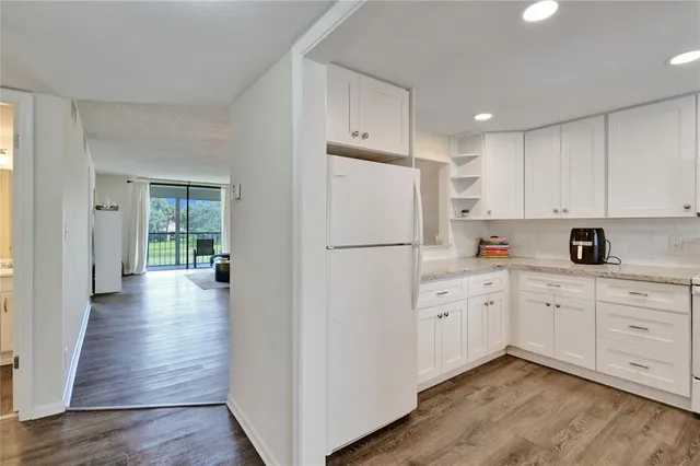 a kitchen with white cabinets and white appliances