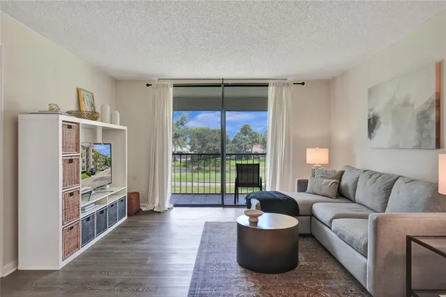 a living room with furniture and a floor to ceiling window