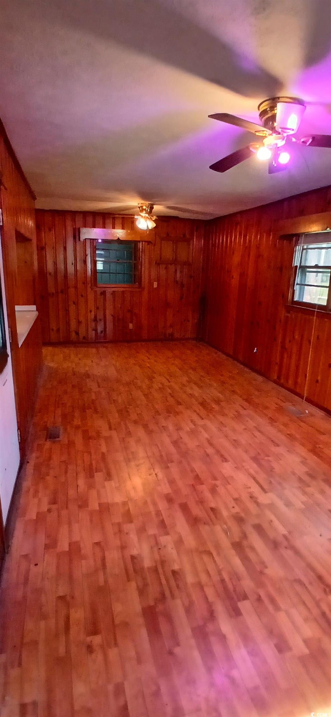 1206 French Road Mullins, SC 29574 - Photo 20 of 31 Unfurnished living room with wooden walls, wood finished floors, and a ceiling fan