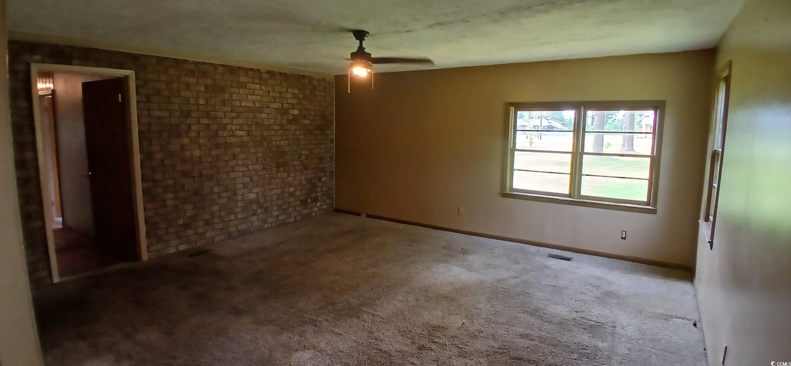 1206 French Road Mullins, SC 29574 - Photo 22 of 31 Unfurnished room featuring a ceiling fan, carpet, and brick wall