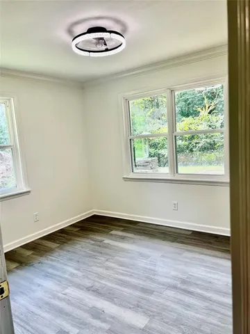 a view of a room with wooden floor and a window