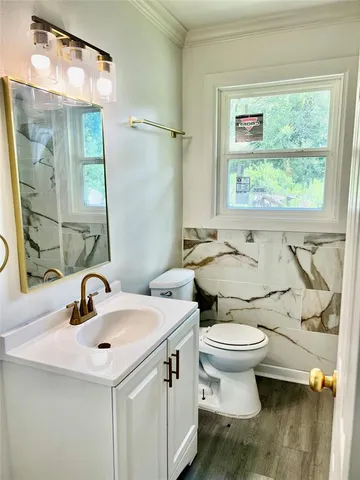 a bathroom with a sink toilet and mirror