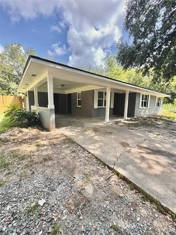 a front view of house with yard and trees in the background