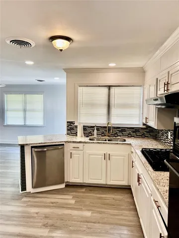 a kitchen with stainless steel appliances granite countertop a stove a sink and a microwave