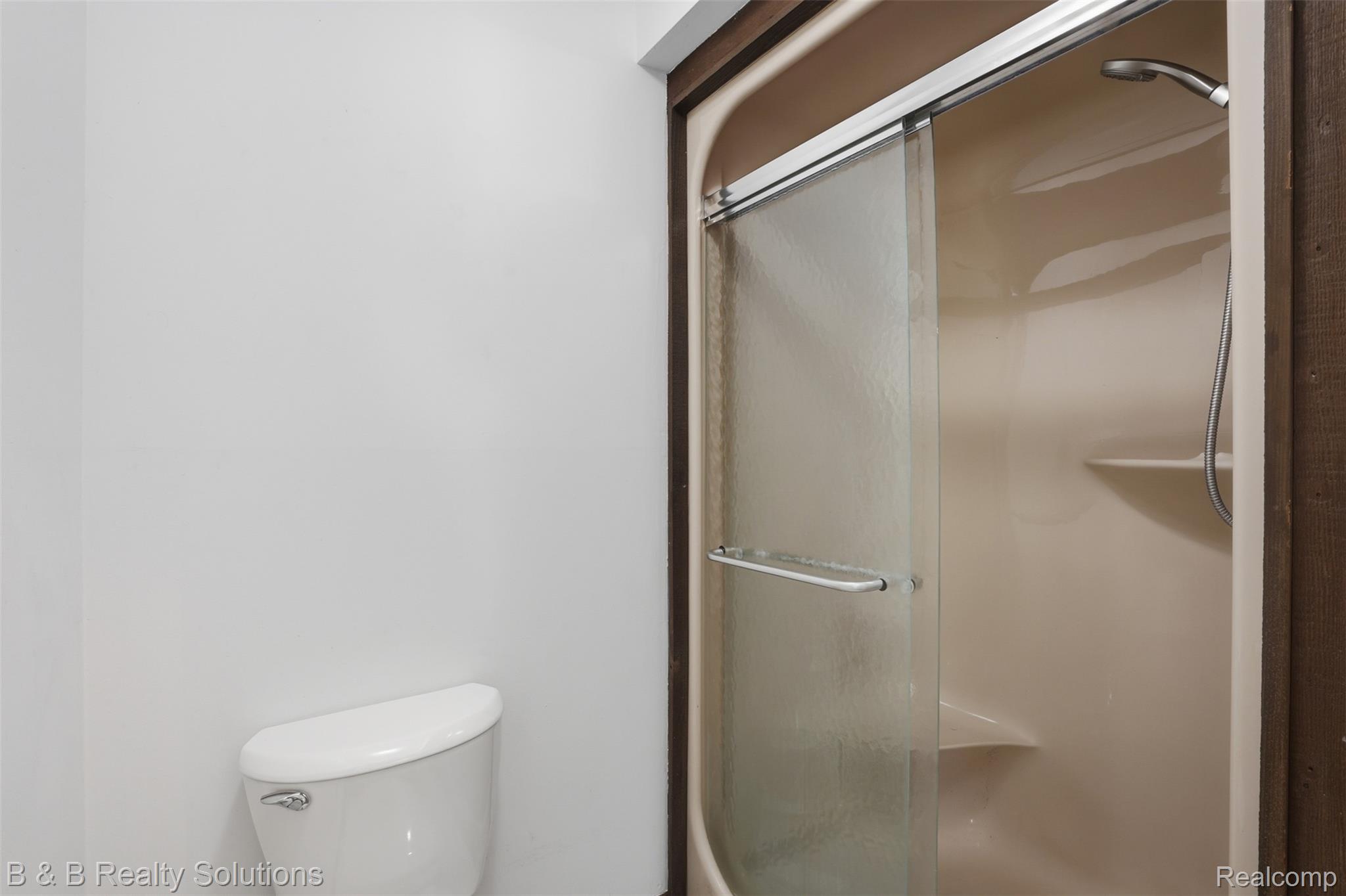 780 North Van Dyke Road, Unit APARTMENT #1 Almont, MI 48003 - Photo 19 of 28 Enclosed shower with sliding glass doors, integrated shelving, and a handheld shower fixture