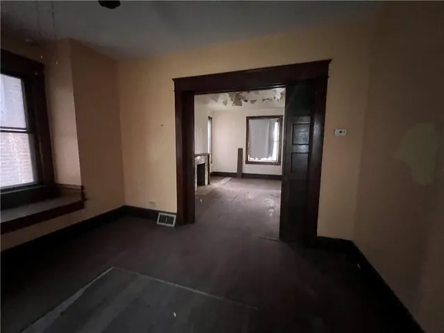 a view of a hallway with wooden floor and a cabinet
