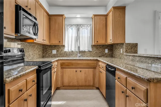 a kitchen with stainless steel appliances granite countertop a sink stove and cabinets