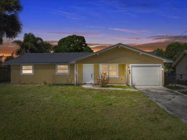 a front view of a house with yard and outdoor seating
