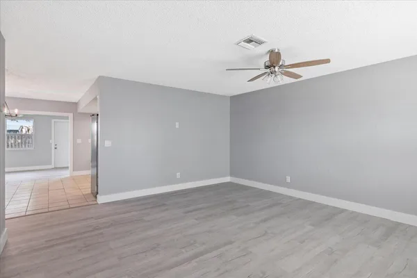a view of an empty room with wooden floor